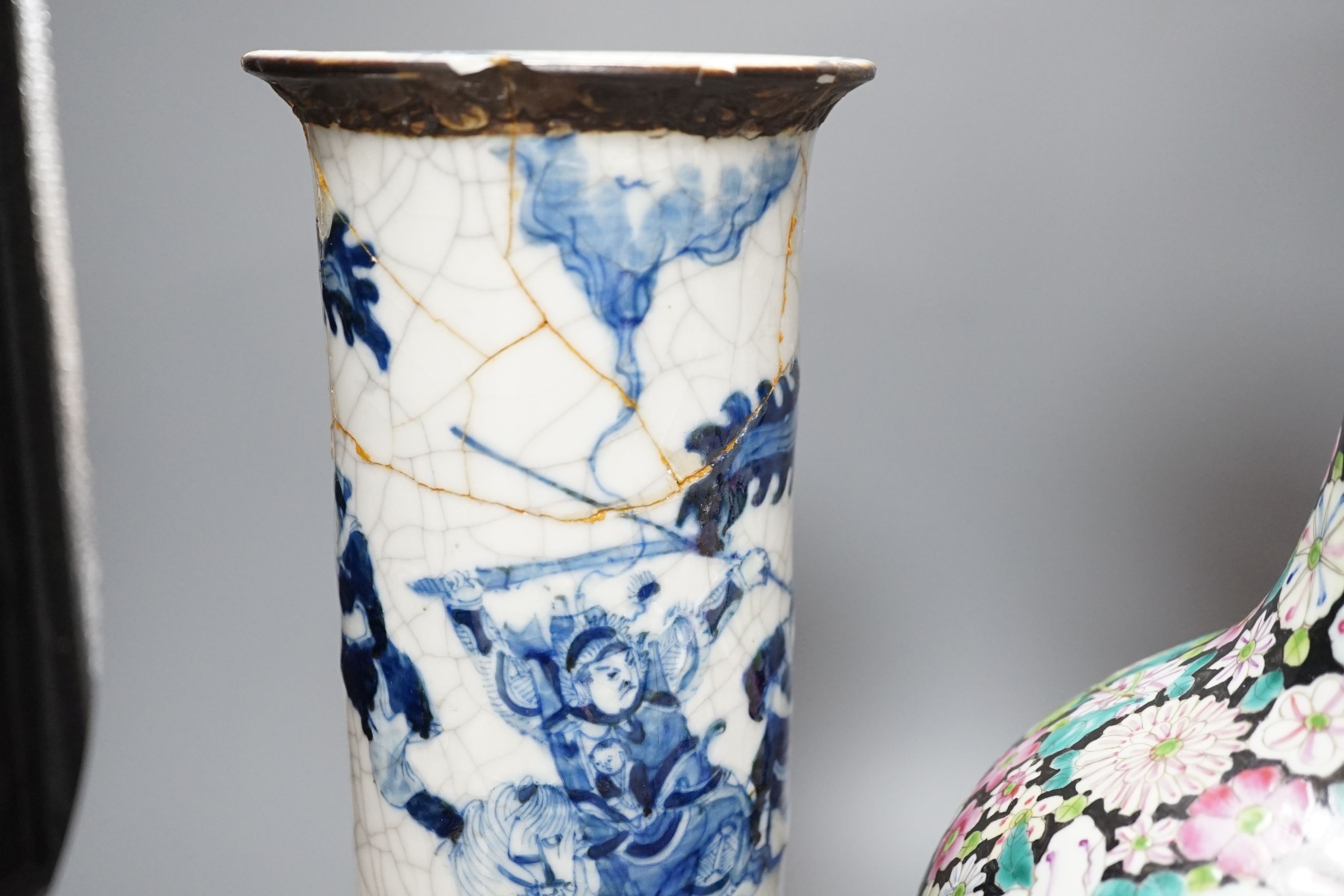 An early 20th century Chinese famille rose thousand flowers bottle vase (restored) together with a Chinese blue and white crackle glazed sleeve vase (a.f)., tallest 40cm
